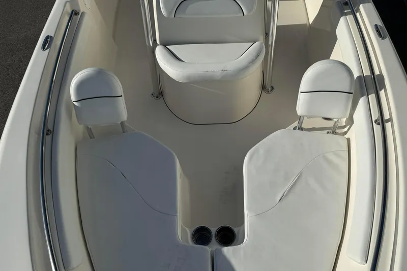 Slide: The Image of 2014 Key West 203 FS boat interior with white cushioned seating and cup holders. - 10