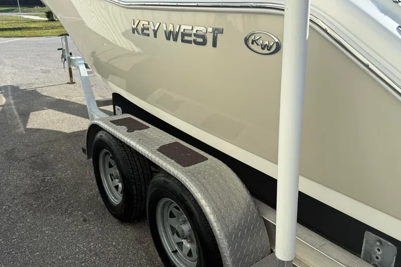 Slide: The Image of 2014 Key West 203 FS boat on a trailer, showcasing brand logo and dual wheels. - 3