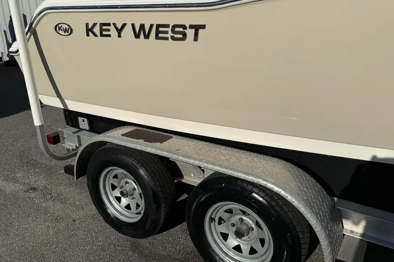 Slide: The Image of 2014 Key West 203 FS boat on trailer, featuring dual wheels and metallic fender. - 4