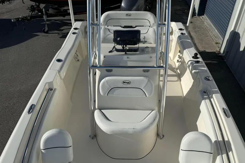Slide: The Image of 2014 Key West 203 FS boat interior with seating and console, parked outdoors. - 9