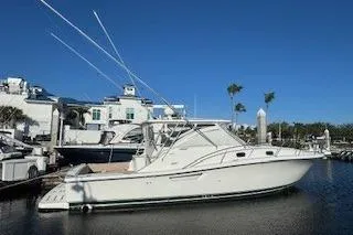 The Image of 2002 Pursuit 3800 Express boat docked at marina under clear blue sky. - 0