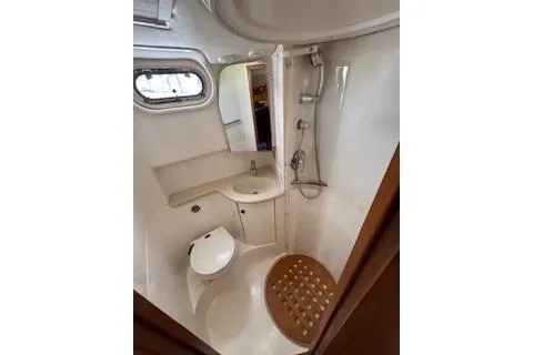 Slide: The Image of 2002 Pursuit 3800 Express boat bathroom with shower, sink, and toilet. - 12