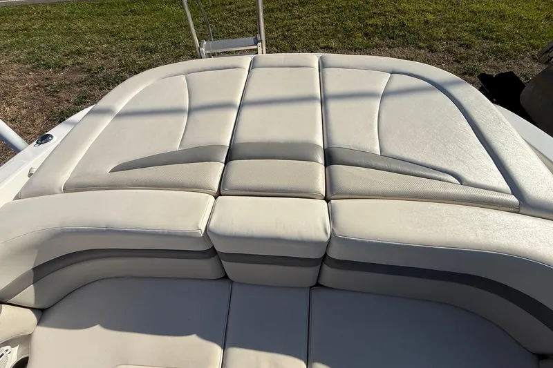 Slide: The Image of 2005 Chaparral 236 SSi boat with beige cushioned seating, outdoor setting. - 23