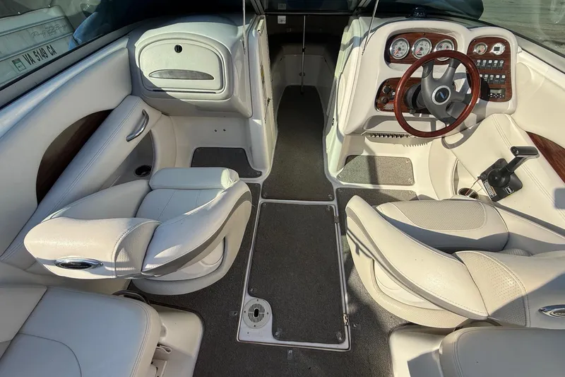 Slide: The Image of 2005 Chaparral 236 SSi boat interior with white seating and wood-accented dashboard. - 24
