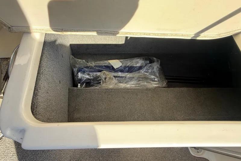 Slide: The Image of Storage compartment in a 2005 Chaparral 236 SSi boat, containing wrapped items. - 27