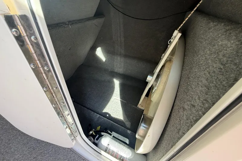 Slide: The Image of Storage compartment in a 2005 Chaparral 236 SSi boat with fire extinguisher. - 32