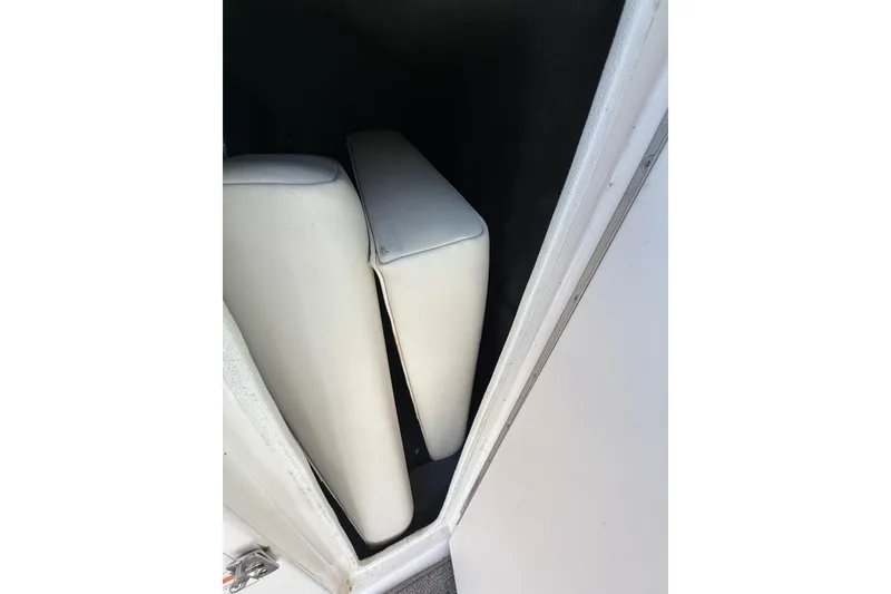 Slide: The Image of White interior cushions in a 2005 Chaparral 236 SSi boat storage compartment. - 34