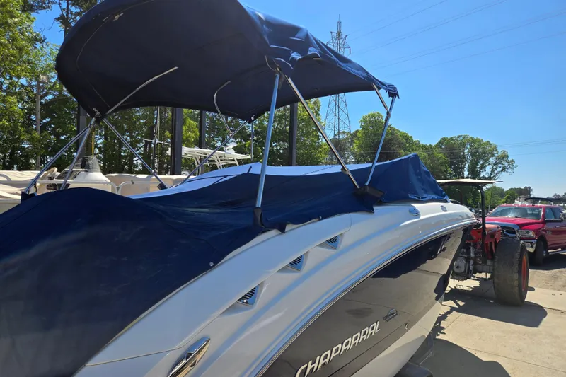 Slide: The Image of 2010 Chaparral Sunesta 224 boat with blue cover and canopy, parked outdoors. - 10