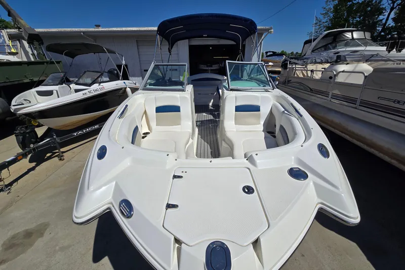 Slide: The Image of 2010 Chaparral Sunesta 224 boat with open bow seating, docked outdoors. - 14