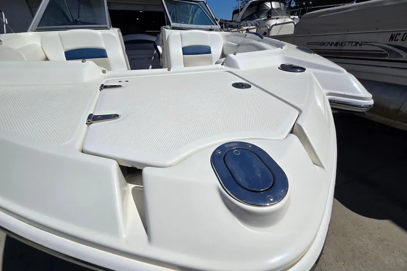 Slide: The Image of 2010 Chaparral Sunesta 224 boat deck, featuring sleek white design and seating area. - 16