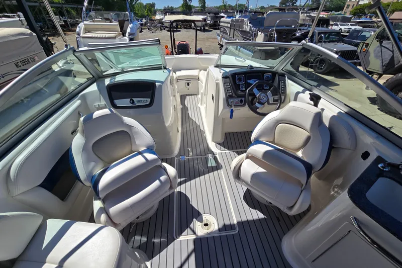 Slide: The Image of 2010 Chaparral Sunesta 224 boat interior with white seating and modern dashboard. - 23