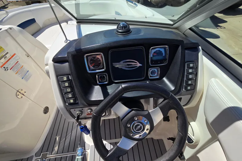 Slide: The Image of 2010 Chaparral Sunesta 224 boat dashboard with steering wheel and control panel. - 25