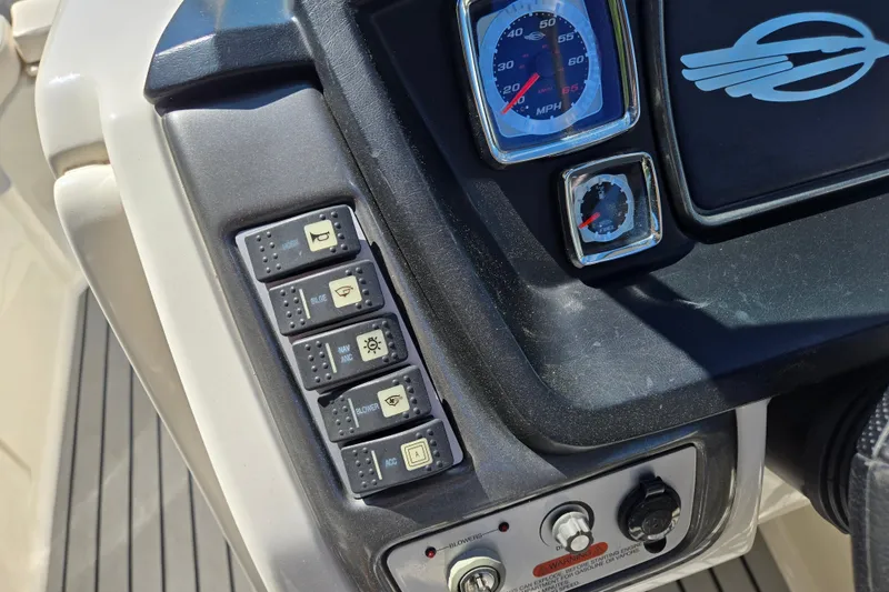 Slide: The Image of Dashboard controls of a 2010 Chaparral Sunesta 224 boat, featuring switches and gauges. - 27