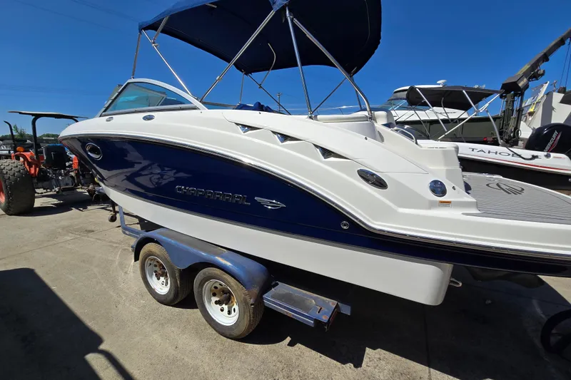 Slide: The Image of 2010 Chaparral Sunesta 224 boat on trailer, blue and white design, sunny day. - 3