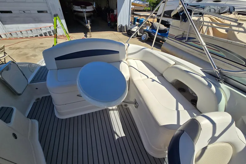 Slide: The Image of 2010 Chaparral Sunesta 224 boat interior with white seating and a round table. - 36