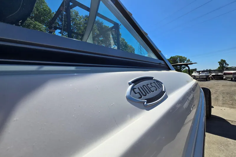 Slide: The Image of 2010 Chaparral Sunesta 224 boat side view with logo, outdoors under clear blue sky. - 6