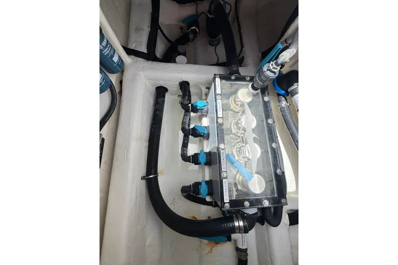 Slide: The Image of Engine compartment of 2024 Invincible 35 Catamaran showcasing hoses and valves. - 17