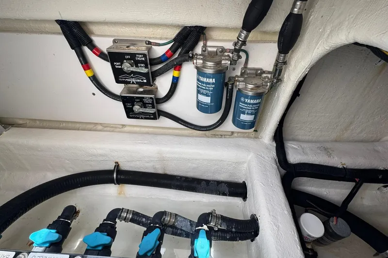 Slide: The Image of Engine compartment of 2024 Invincible 35 Catamaran with Yamaha fuel-water separators and control switches. - 19