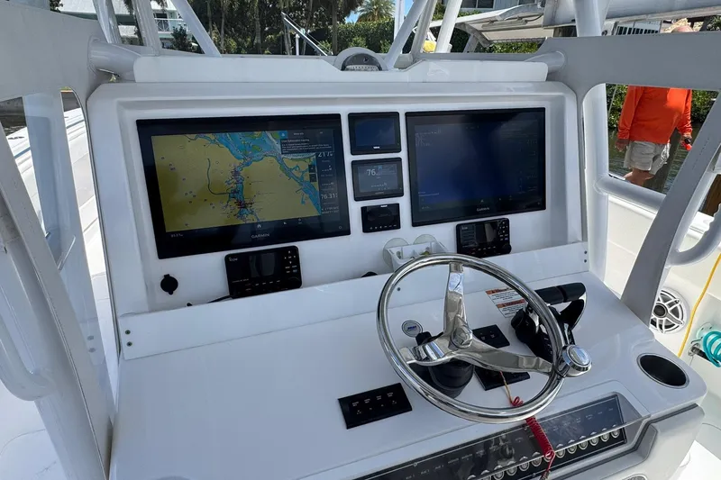 Slide: The Image of 2024 Invincible 35 Catamaran helm with dual Garmin displays and steering wheel. - 2