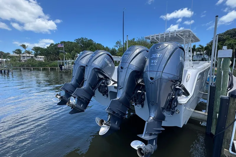 Slide: The Image of 2024 Invincible 35 Catamaran with triple Yamaha 300 V6 outboard engines docked by the water. - 24