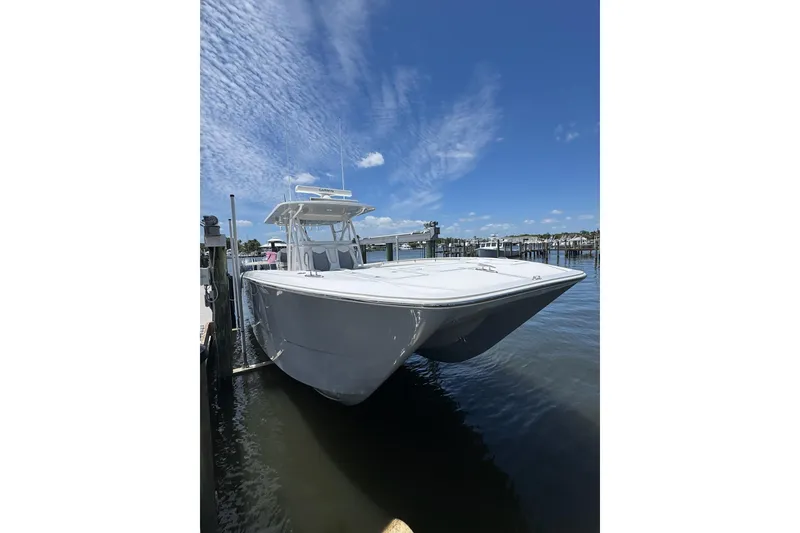Slide: The Image of 2024 Invincible 35 Catamaran docked, showcasing sleek design under a clear blue sky. - 26