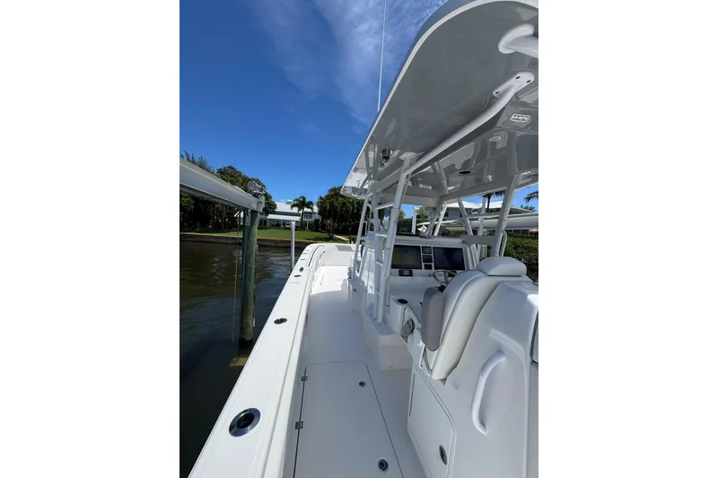 Slide: The Image of 2024 Invincible 35 Catamaran, sleek white deck, modern helm, clear blue sky backdrop. - 4