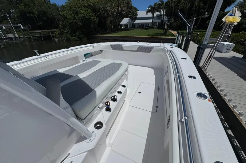 Slide: The Image of 2024 Invincible 35 Catamaran with spacious seating and sleek design docked by lush greenery. - 7