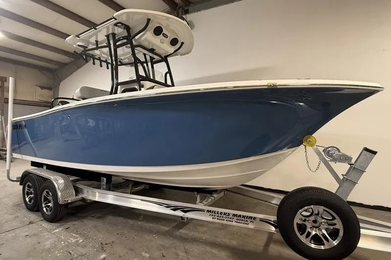 Slide: The Image of 2026 Sea Pro 225 FLXR Sandbar boat on trailer in indoor storage. - 2