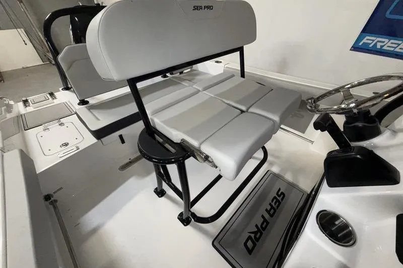 Slide: The Image of 2026 Sea Pro 225 FLXR Sandbar boat interior with sleek seating and steering wheel. - 7