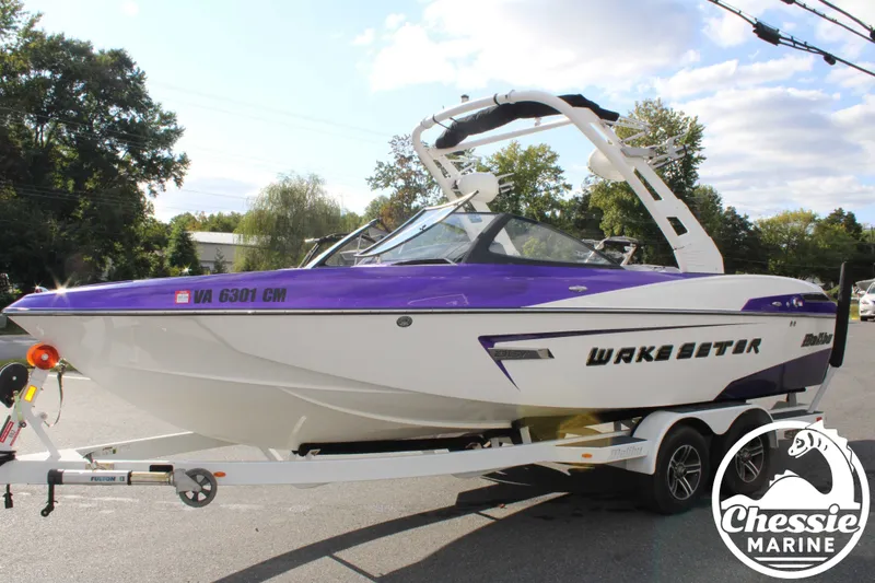 The Image of 2015 Malibu Wakesetter 23 LSV boat on trailer, purple and white. - 1