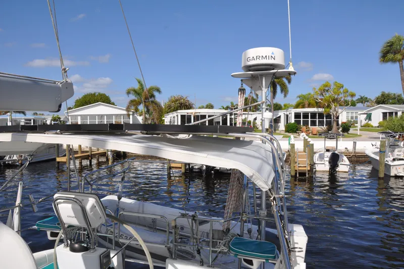 Slide: The Image of Catalina 387 sailboat docked near waterfront homes, featuring Garmin equipment, under clear blue skies. - 16