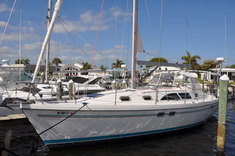 Slide: The Image of 2003 Catalina 387 sailboat docked at marina under clear blue sky. - 3