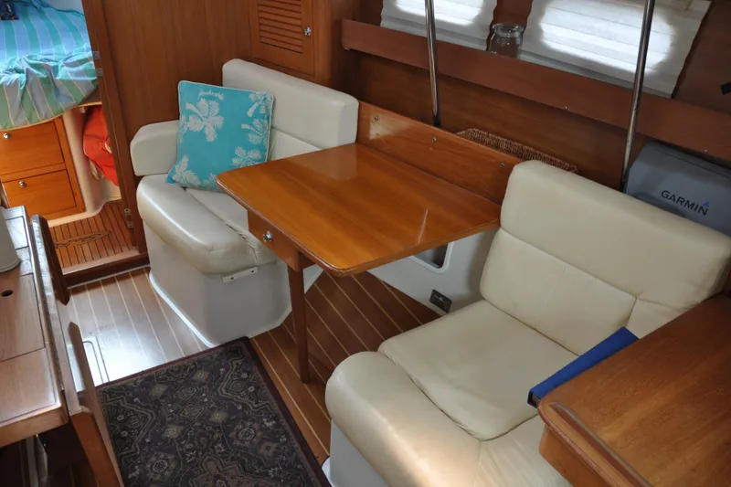 Slide: The Image of Interior of 2003 Catalina 387 sailboat with cozy seating and wooden table. - 34