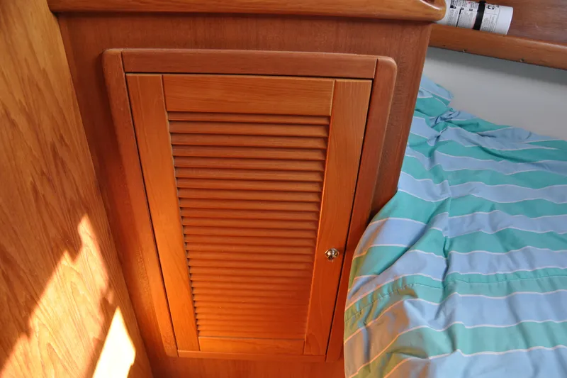 Slide: The Image of Wooden cabinet door beside striped bedding in 2003 Catalina 387 yacht interior. - 45