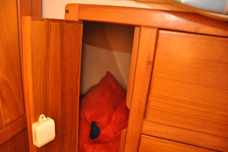 Slide: The Image of Wooden cabinet with open door revealing red life jacket inside, Catalina 387, 2003 model. - 49