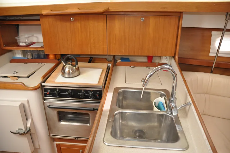 Slide: The Image of Compact kitchen in 2003 Catalina 387 yacht with stove, sink, and wooden cabinets. - 51
