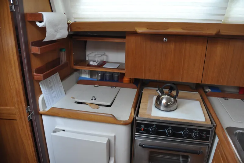 Slide: The Image of Compact kitchen area in a 2003 Catalina 387 sailboat with stove and storage. - 52