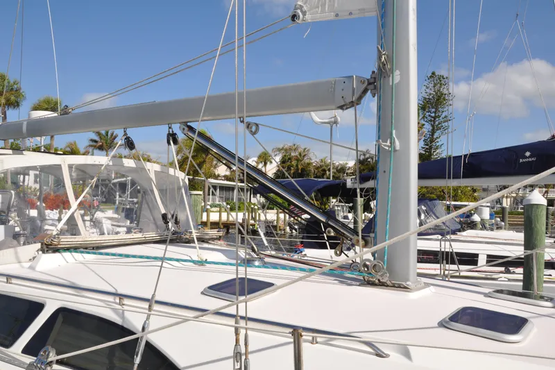 Slide: The Image of 2003 Catalina 387 sailboat docked, featuring rigging and deck details under a clear blue sky. - 6