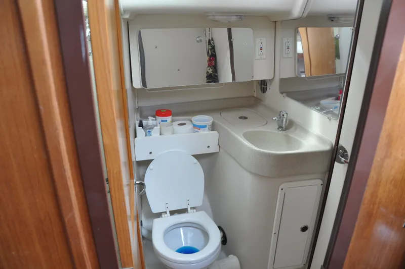 Slide: The Image of Compact bathroom in a 2003 Catalina 387 yacht, featuring a toilet and sink. - 63