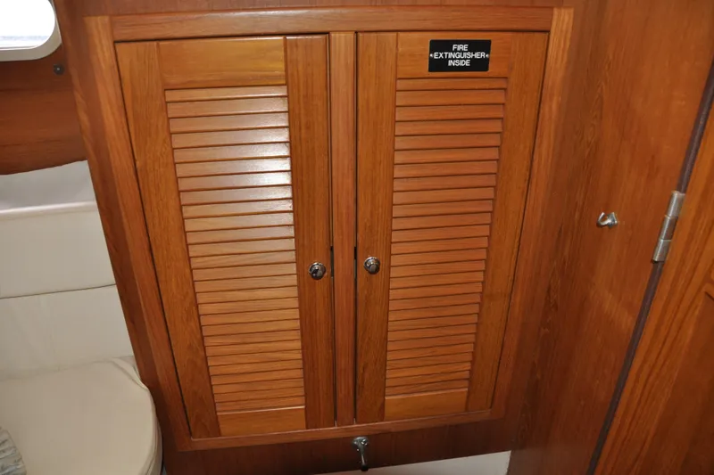 Slide: The Image of Wooden cabinet with fire extinguisher inside, aboard 2003 Catalina 387 sailboat. - 69