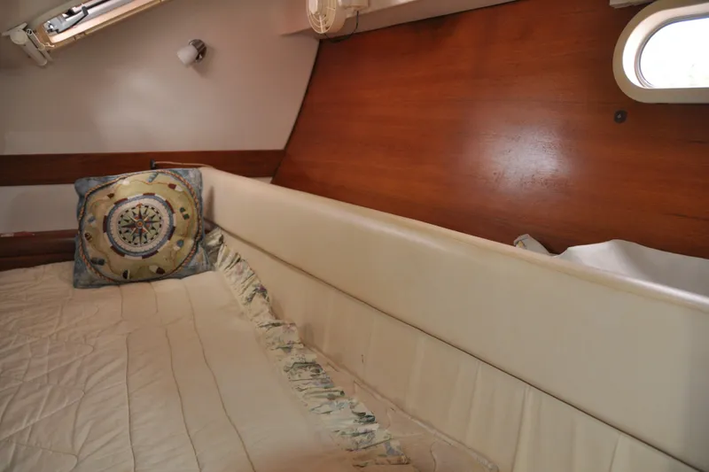 Slide: The Image of Cozy cabin interior of 2003 Catalina 387 sailboat with decorative pillow and wooden paneling. - 71