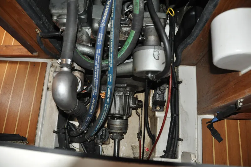 Slide: The Image of Engine compartment of a 2003 Catalina 387 sailboat, showing hoses and mechanical components. - 79
