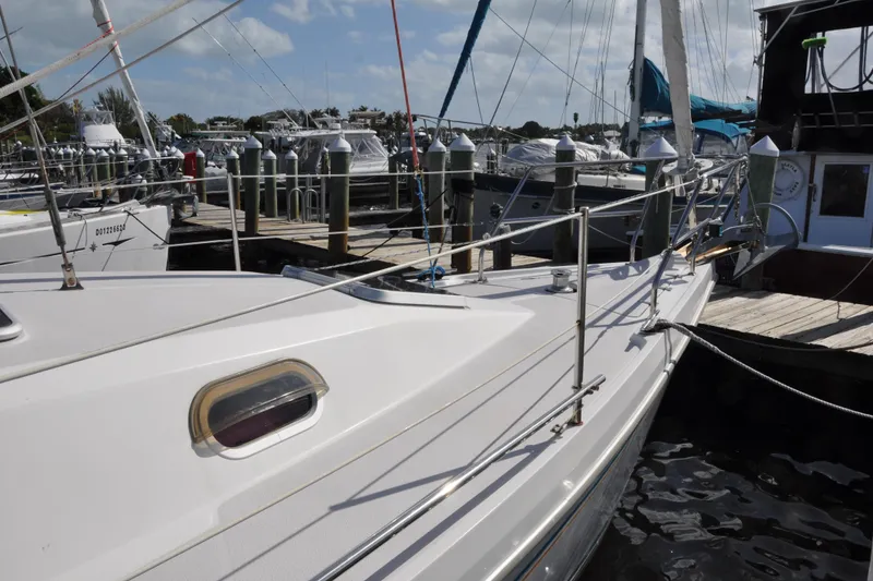Slide: The Image of 2003 Catalina 387 sailboat docked at a marina under a clear blue sky. - 8