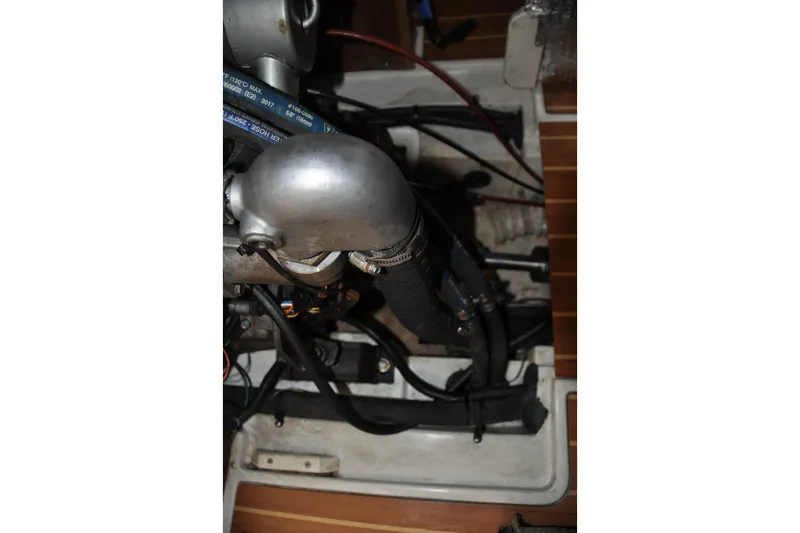 Slide: The Image of Engine compartment of a 2003 Catalina 387 sailboat, showing hoses and metal components. - 81