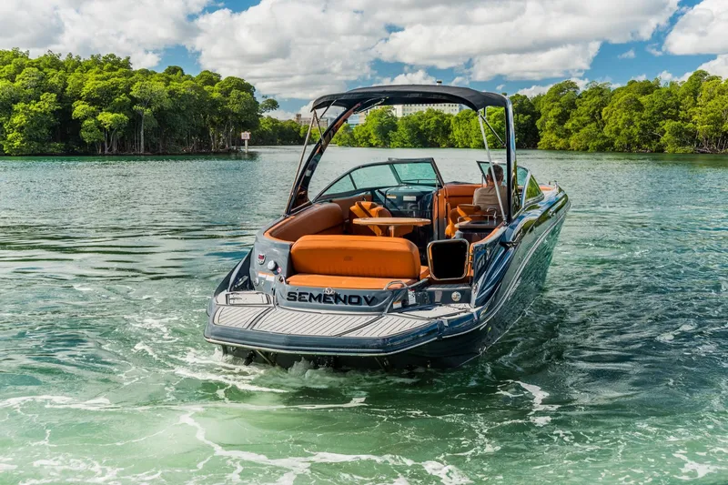 Slide: The Image of 2017 Cruisers Sport Series 298 Bow Rider on scenic waterway with lush greenery. - 2