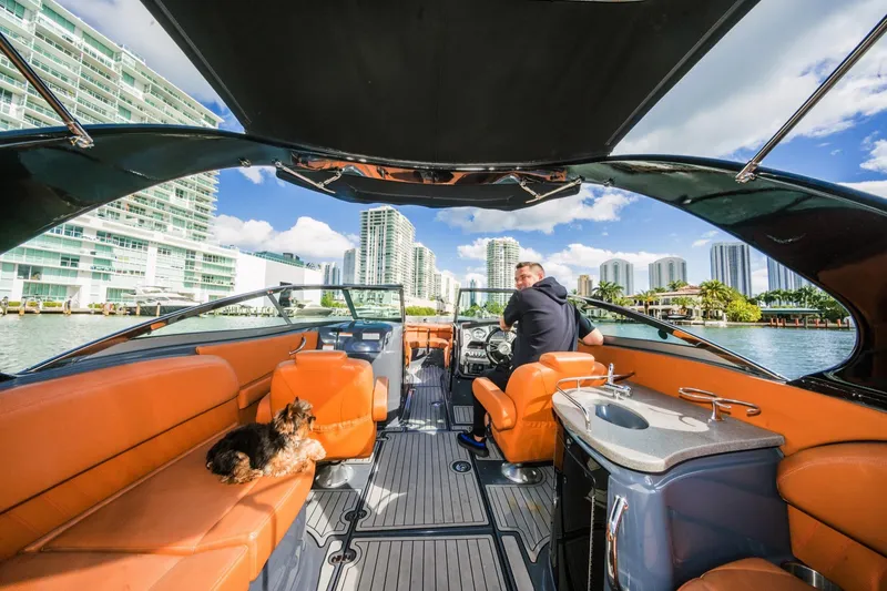 Slide: The Image of 2017 Cruisers Sport Series 298 Bow Rider South Beach Edition on water, city skyline view. - 26