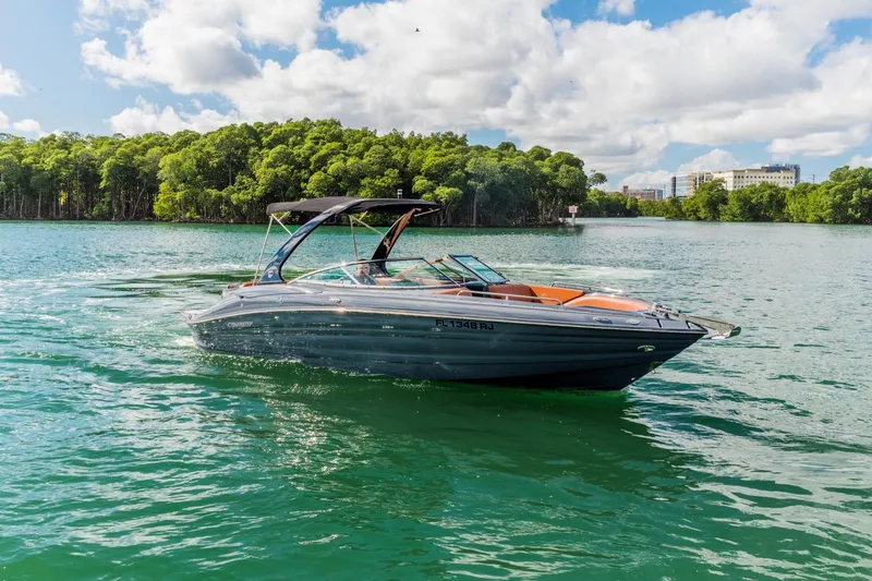 Slide: The Image of 2017 Cruisers Sport Series 298 Bow Rider on scenic waterway, lush greenery background. - 4