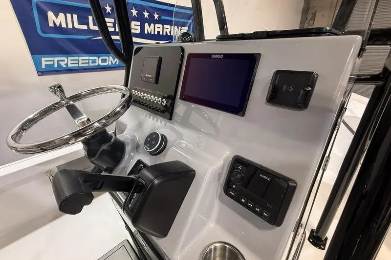 Slide: The Image of 2026 Sea Pro 230 Bay boat dashboard with steering wheel and electronic controls. - 13