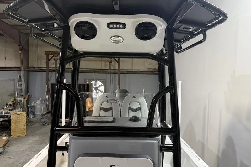 Slide: The Image of 2026 Sea Pro 230 Bay boat interior with T-top and seating in a workshop. - 17