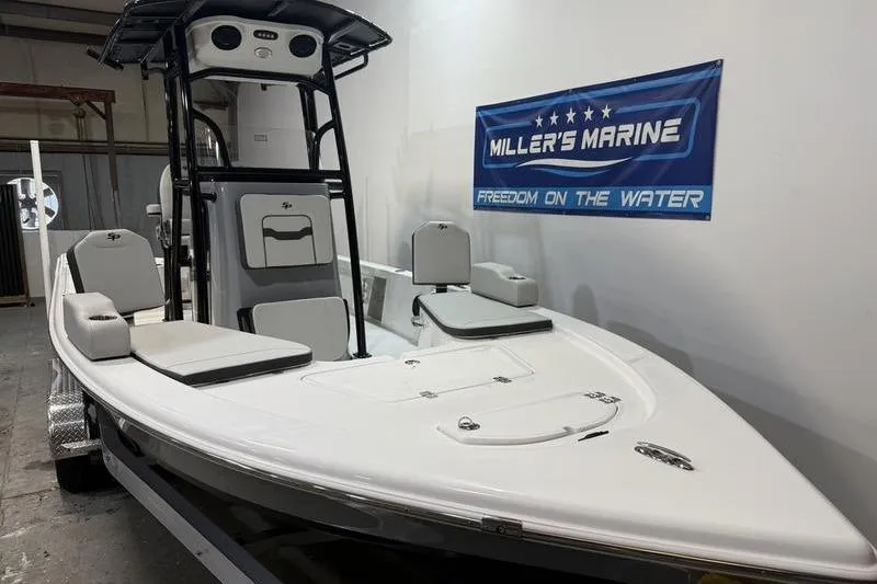 Slide: The Image of 2026 Sea Pro 230 Bay boat displayed indoors at Miller's Marine showroom. - 2
